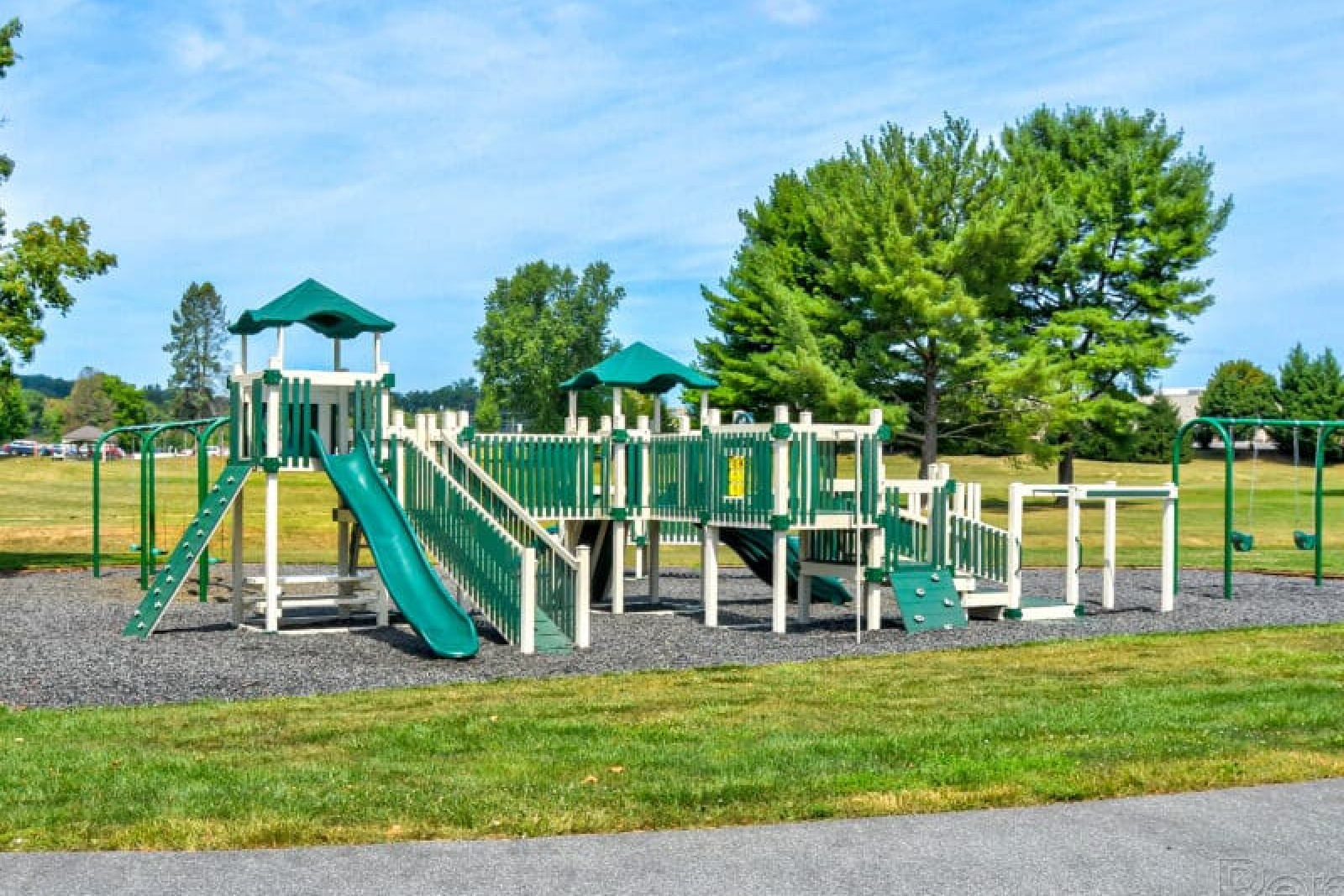 Playground over a gravel area with a clear blue sky
