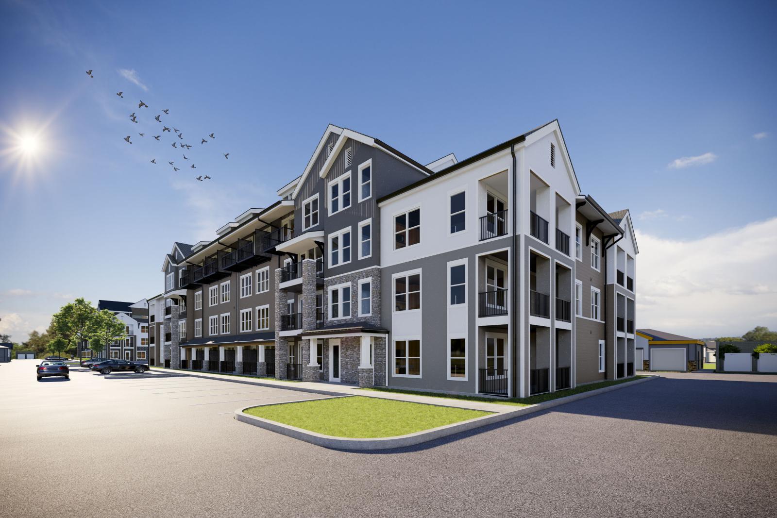 Modern three-story apartment building under bright sun at The Pointe at Overlook, featuring private balconies and stone accents