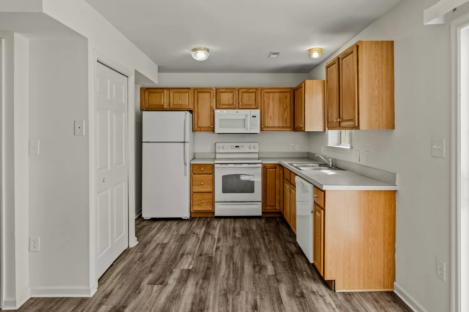 Spacious kitchen at Windsor Commons Townhomes with full-size refrigerator, oven, microwave, dishwasher, and ample cabinet storag