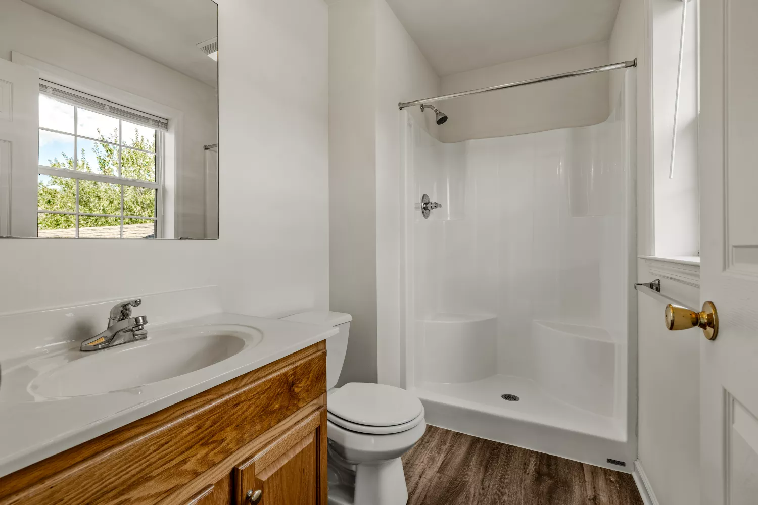 Modern bathroom at Windsor Commons Townhomes with wide vanity, mirror, and walk-in shower with built-in seating