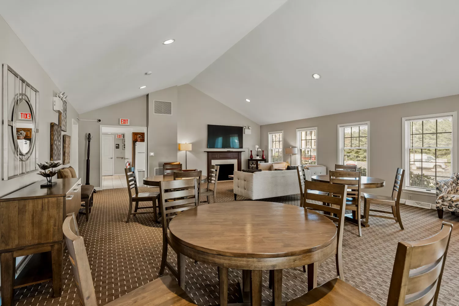 Resident clubhouse at Windsor Commons Townhomes with lounge seating, TV, fireplace, and tables for community gatherings