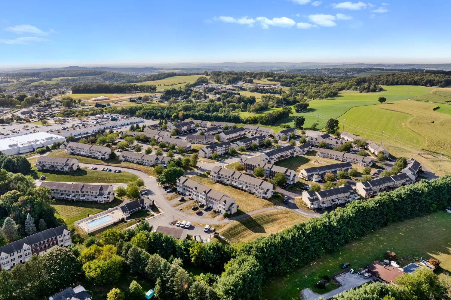 Aerial view of Windsor Commons Townhomes community showing landscaped grounds, townhome buildings, and surrounding countryside