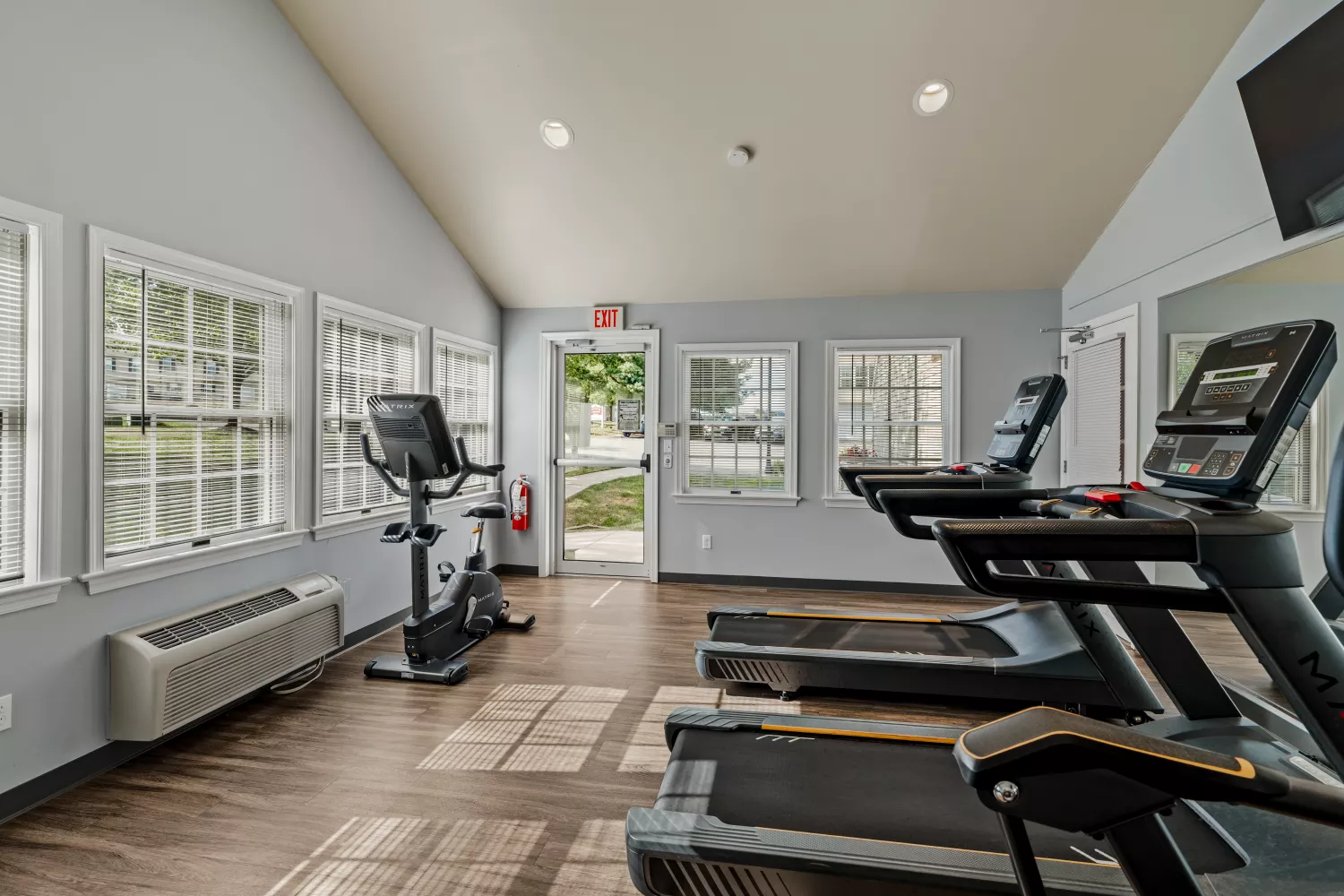 Windsor Commons Townhomes fitness center with treadmills, stationary bike, and large windows providing natural light