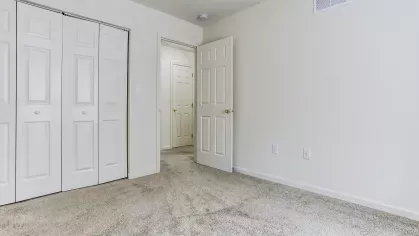 ozy bedroom at Mill Creek Manor with closet doors and view into hallway
