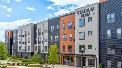 Panoramic view of Stadium Row apartment buildings, showcasing the unique multi-colored facade, numerous windows, and well-maintained landscaping, reflecting the vibrant community atmosphere.
