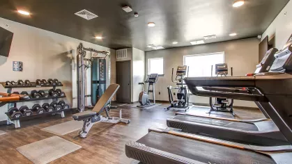 Spacious gym at Stadium Row featuring state-of-the-art exercise equipment including treadmills, ellipticals, weight racks, and strength training machines for resident use.