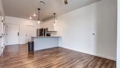 Panoramic view of the open-plan living and kitchen area in the Stretch 423 floor plan at Stadium Row, showcasing the spacious layout, modern finishes, and large windows.