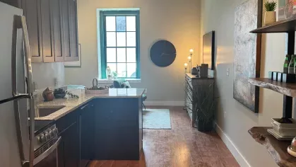 View from kitchen to living area in Prince Street Lofts apartment with open-concept design and natural light