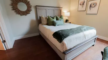 Bedroom with wood floors, upholstered headboard, and decorative pillows at Prince Street Lofts apartment