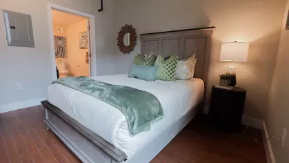 Modern bedroom with wood floors and neutral decor at Prince Street Lofts