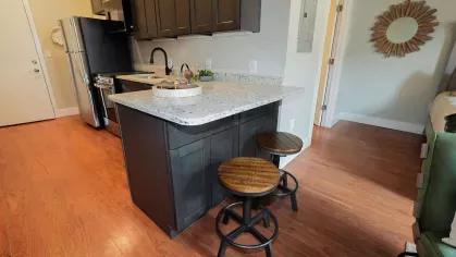 Breakfast bar with wood stools and granite counters in a Prince Street Lofts apartment kitchen
