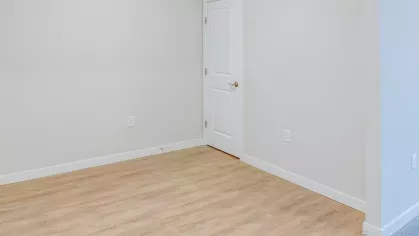 A versatile den or flex space at Riverview Terrace, featuring durable wood-style flooring and neutral walls, perfect for a home office, study, or extra living area in your apartment.