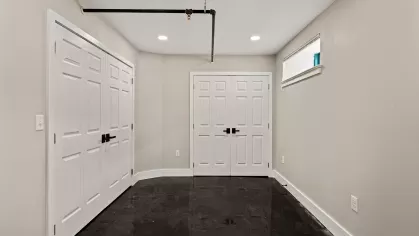 Bedroom space with double-door closets, high ceilings, and a transom window offering natural light.