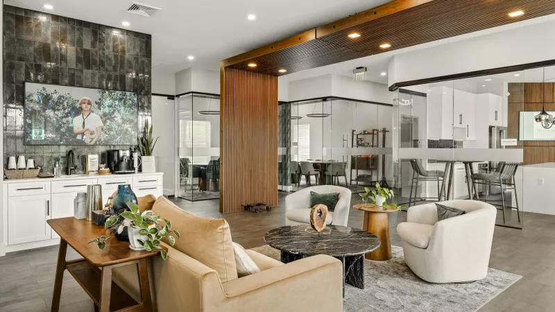 Contemporary leasing office and resident lounge at The Foundry featuring comfortable seating, coffee station, and modern glass-walled meeting rooms.