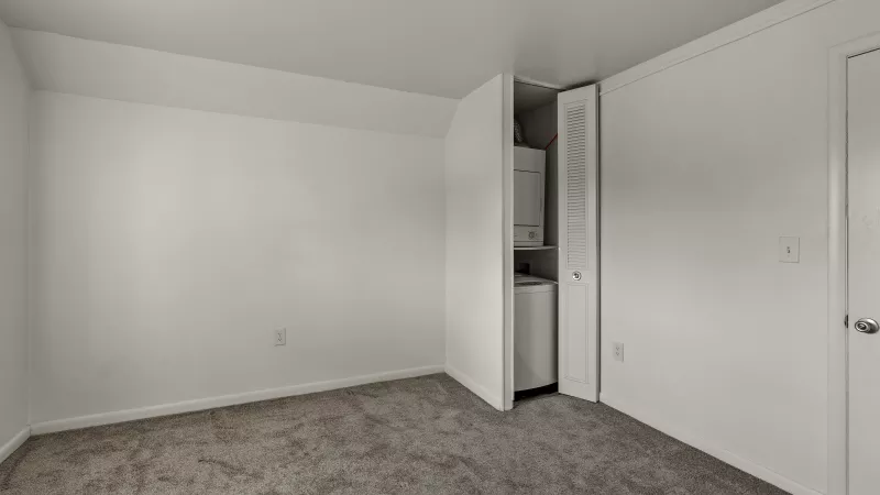 Bedroom at Rosedale Apartments with in-unit washer and dryer tucked inside closet for added convenience