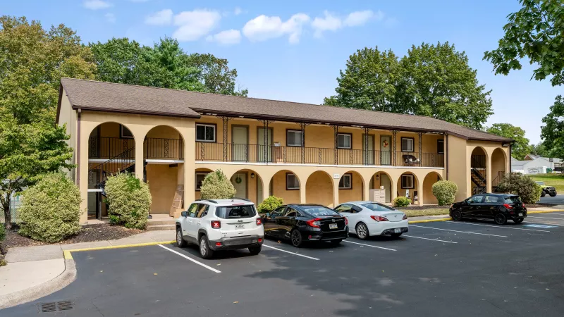 Rosedale Apartments exterior view with resident parking lot, landscaped grounds, and multi-story apartment buildings