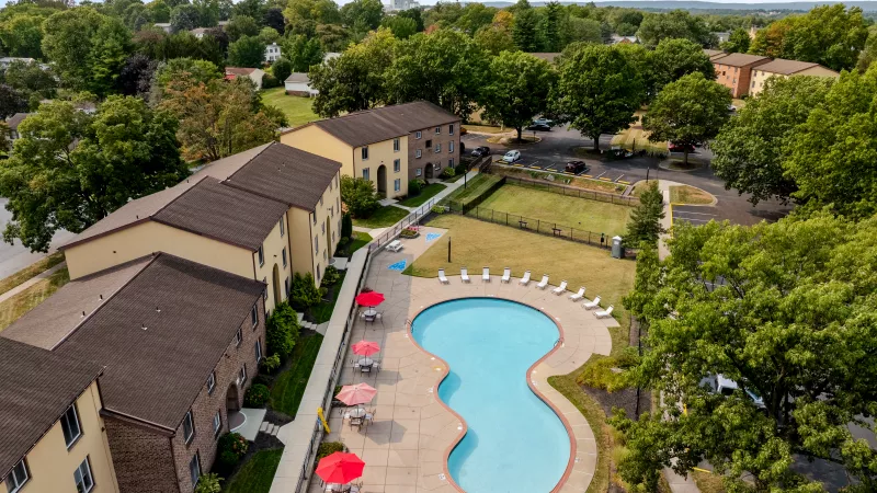 Aerial view of Rosedale Apartments highlighting the large outdoor pool, sun deck, and surrounding apartment buildings