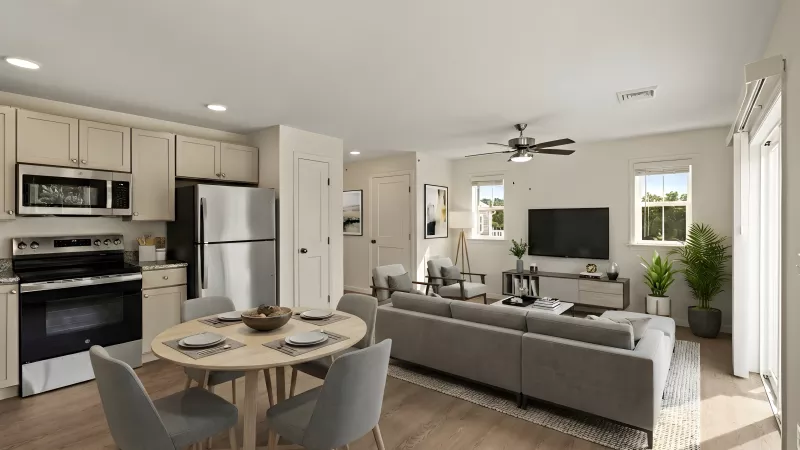 Modern open-concept living space with kitchen, dining table, and living room featuring a gray sectional sofa.