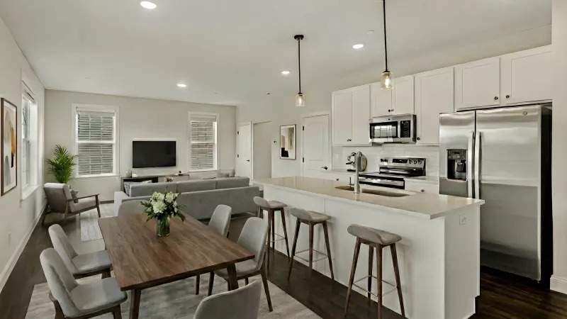 Open-plan living room, dining area, and modern kitchen with white cabinets, stainless steel appliances, and dark wood floors.