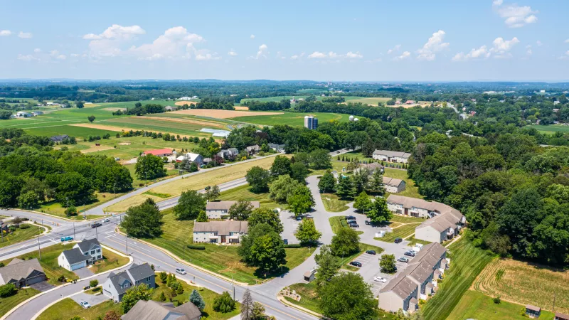 levated aerial view highlighting Pioneer Woods’ location at a key intersection, with nearby homes, trees, and wide views of the Lancaster County countryside.