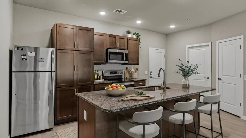 Modern kitchen with dark wood cabinets, stainless steel appliances, and a granite island with three bar stools.