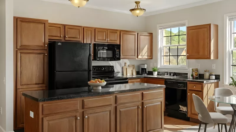 Well-lit kitchen with wooden cabinets, black appliances, granite countertops, and a dining table.