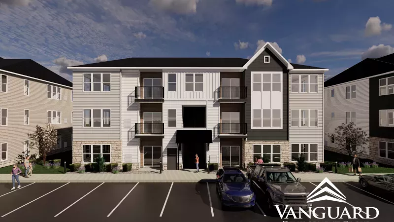 Rendering of a modern, multi-story apartment building with grey and white siding, balconies, and a parking lot. Vanguard Development Group logo.