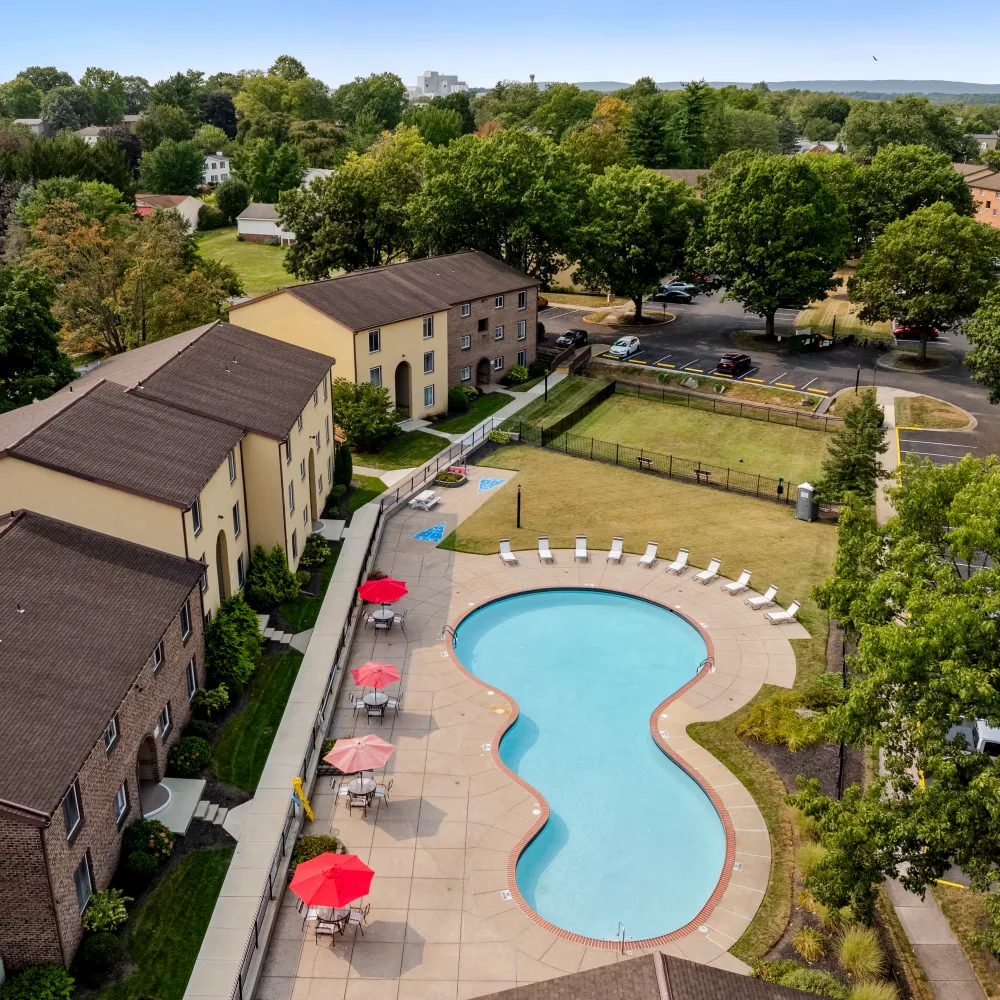 Aerial view of Rosedale Apartments highlighting the large outdoor pool, sun deck, and surrounding apartment buildings