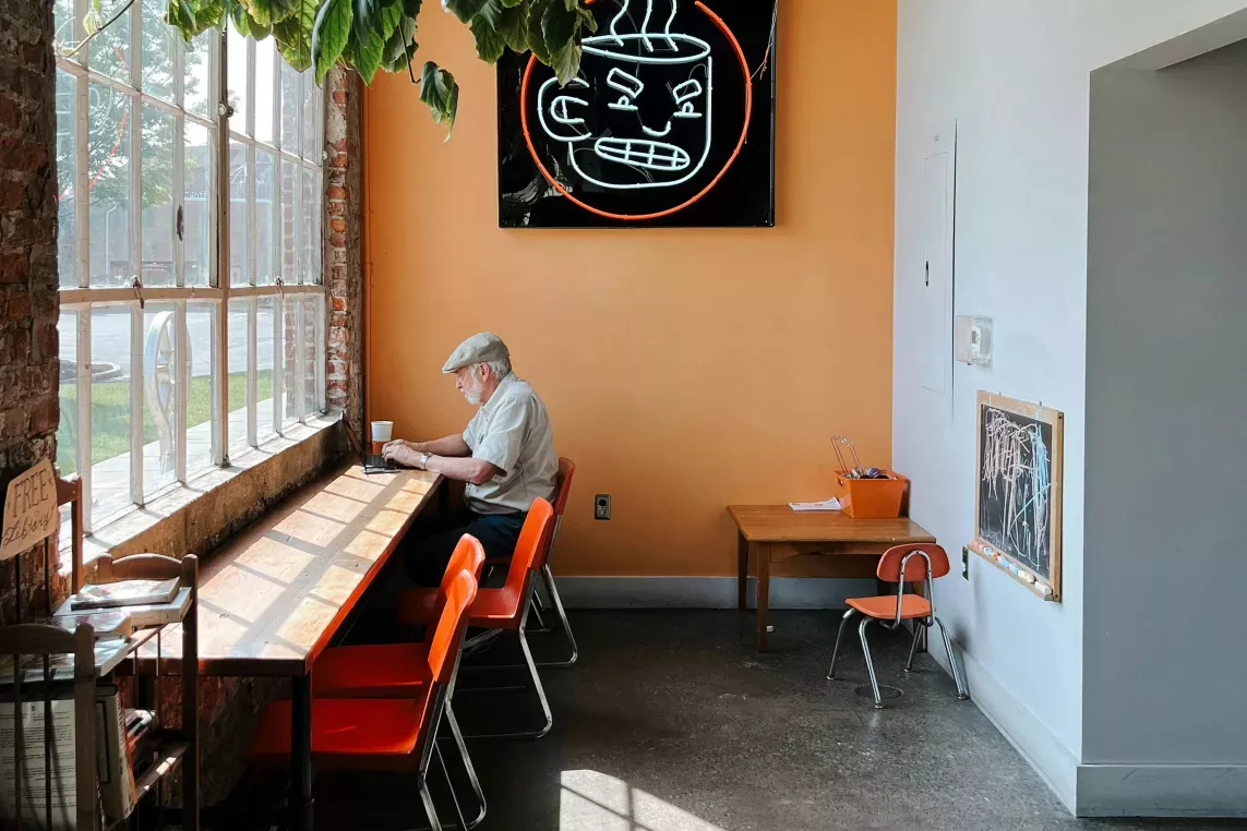 open, colorful cafe with an individual enjoying peace & quiet in the sunshine