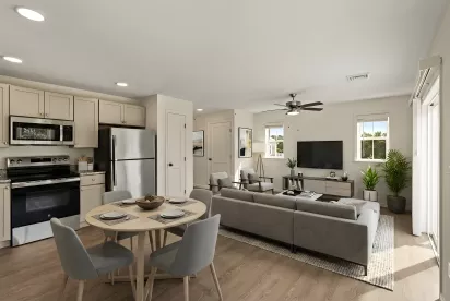 Modern open-concept living space with kitchen, dining table, and living room featuring a gray sectional sofa.