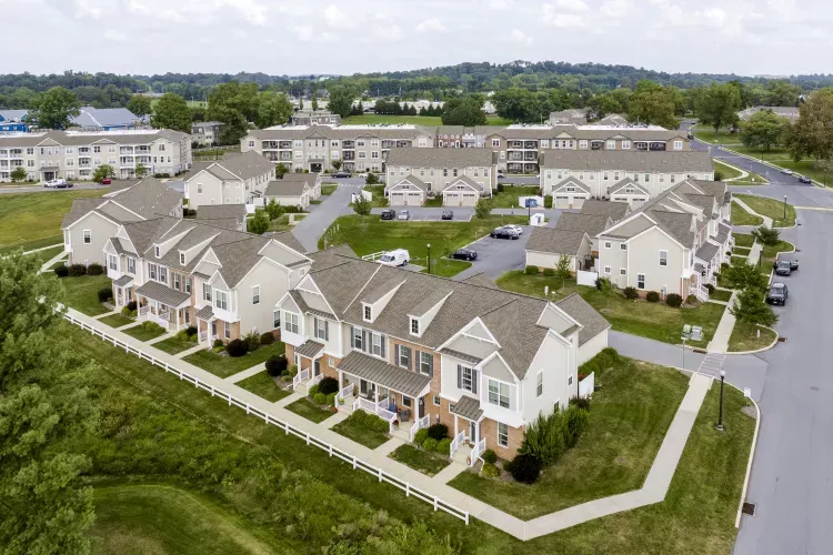 Aerial photograph of a residential neighborhood with numerous beige townhouses and apartment buildings.